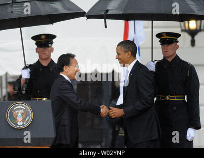 Us-Präsident Barack Obama (R) schüttelt Hände mit südkoreanischen Präsidenten Lee Myung-bak, wie er begrüßt ihn im Regen an das Weiße Haus auf der South Lawn in Washington, DC am 13. Oktober 2011. Der Staatsbesuch kommt nur einen Tag nach dem Kongress ein Freihandelsabkommen mit Südkorea verabschiedet. UPI/Pat Benic Stockfoto