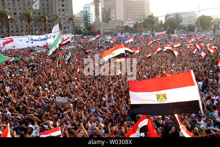 Ägypter heben die Hand und skandieren Parolen, wie Sie sammeln für eine Rede, die der designierte Präsident Mohammed Morsi auf dem Tahrir-Platz in Kairo, Ägypten, 29. Juni 2012. Morsi würdigte Ägyptens Muslime und Christen gleichermaßen und symbolisch schwor sich als erste gewählte zivile Präsident des Landes. UPI/Ahmed Jomaa Stockfoto