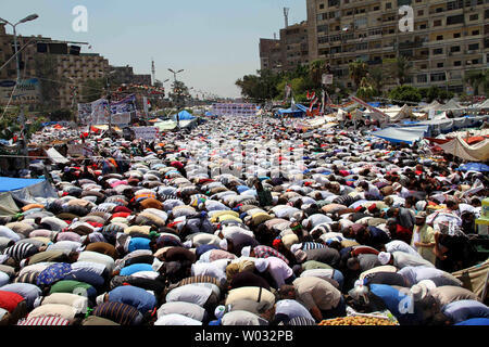 Anhänger des abgesetzten Ägyptischen Präsidenten Mohamed Morsi beten während eines Protestes außerhalb Raba El-Adwyia Moschee in Kairo in Ägypten, 26. Juli 2013. Dutzende Menschen haben in der Nacht zu Zusammenstößen zwischen Sicherheitskräften und Anhängern des gestürzten Ägyptischen Präsidenten Mohamed Morsi getötet worden. UPI/Ahmed Jomaa Stockfoto