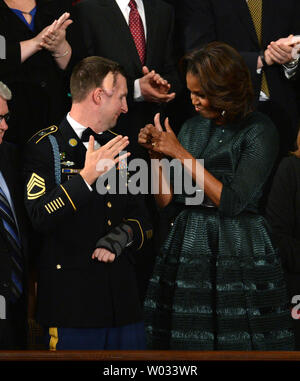 First Lady Michelle Obama gibt den Daumen bis zu Army Ranger Sergeant First Class Cory Remsburg, die verletzt wurde, während in Afghanistan dienen, da sie eine Standing Ovation vor der Ankunft von US-Präsident Barack Obama bei seiner Rede zur Lage der Union im Haus Kammer am Kapitol am 28 Januar, 2014 in Washington, DC. UPI/Pat Benic Stockfoto