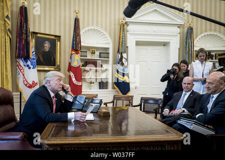 U.S. National Security Advisor H.R. McMaster und Chief wirtschaftlichen Berater Gary Cohn (Rechts) Blick auf als Präsident Donald Trump spricht mit Premierminister Leo Varadkar von Irland per Telefon im Oval Office im Weißen Haus am 27. Juni 2017 in Washington, D.C., Trumpf, der Aufruf, den neu gewählten Ministerpräsidenten und derzeitigen Taoiseach gratulieren. Der Führer der Fine Gael Partei, Varadkar wurde nach dem Ausscheiden von Enda Kenny gewählt. Foto von Pete Marovich/UPI Stockfoto