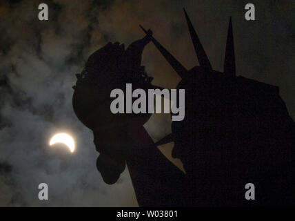 Eine partielle Sonnenfinsternis bewegt sich über den Himmel in der Nähe der Krone und der Fackel der Freiheitsstatue auf Liberty Island am 21. August 2017 in New York City. Heute ist die lange erwartete Sonnenfinsternis verdunkelte sich der Himmel von Oregon nach South Carolina wie der Mond zwischen Erde und Sonne. Das letzte Mal die aneinandergrenzenden Staaten der USA sah eine totale Sonnenfinsternis 1979 war, und der nächste wird nicht bis 2024. Foto von John angelillo/UPI Stockfoto