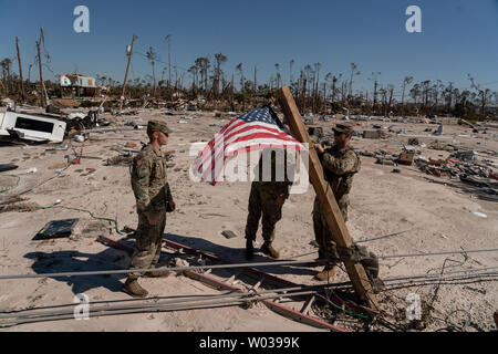 Spc. Sean Westmoreland, SPC. Herbert Joyner, und Pfc. Jeremy Grant, von die 153 Charlie Truppe in Tallahassee, hängen die amerikanische Flagge auf einem 4x4 von Ablagerungen nach dem Hurrikan Michael in Mexiko Beach, Florida, 13. Oktober 2018 schlug. Foto von Ken Cedeño/UPI Stockfoto