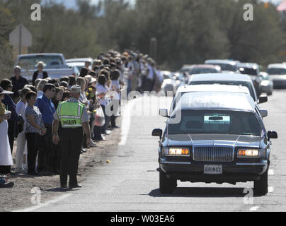 Der leichenwagen mit dem Sarg mit den sterblichen Überresten von Christina Taylor Grün führt eine Prozession vorbei an einer Reihe von Menschen wie es Köpfe zu ihrer Beerdigung in Tucson, Arizona, 13. Januar 2011. Grün war das jüngste Opfer der Samstag schießen in Tucson, der linken sechs Menschen getötet und 13 verwundet, darunter Rep. Gabriella Giffords (D-AZ). UPI/Kunst Foxall Stockfoto