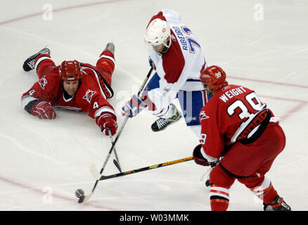Aaron Carolina Hurricanes' Ward, Links, und Doug Weight, rechts, erreicht für den Kobold als Montreal Canadiens' Mike Ribeiro skates zwischen ihnen in den ersten überstunden, während Spiel 2 der NHL Eastern Conference Viertelfinale im RBC Center in Raleigh, NC 24. April 2006. Montreal gewann in der zweiten überstundenperiode, 6-5. (UPI Foto/Jeffrey A. Camarati) Stockfoto