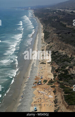 Die Juaneno Band der Mission Inder, Acjachemen Nation und Hunderte Demonstranten sammeln ihre angestammten tar Mann" und das Wort "?!" auf San Onofre Strand am 9. Juni in San Onofre, Kalifornien 2018. Der Banner sollte Licht auf die Stilllegung des nahe gelegenen San Onofre Nuclear Power Plant die Organisatoren sagen, die verheerende Auswirkungen auf den südlichen Kalifornien und zukünftige genterations haben könnte zu vergießen. Die Veranstaltung war Teil der Acjachemen Weisheit Tag Feier. Foto von Lou Dematteis/UPI Stockfoto