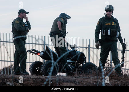 Us Border Patrol-Agenten watch illegals in San Ysidro, Kalifornien am Dezember 2, 2018. Mit wachsender Frustration an die Dauer der Asylverfahren, ein Dutzend Migranten entscheiden, den Grenzzaun, teilt den Vereinigten Staaten und Mexiko zu springen. Foto von Ariana Drehsler/UPI Stockfoto