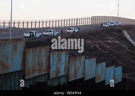 Us Border Patrol-Agenten watch illegals in San Ysidro, Kalifornien am Dezember 2, 2018. Mit wachsender Frustration an die Dauer der Asylverfahren, ein Dutzend Migranten entscheiden, den Grenzzaun, teilt den Vereinigten Staaten und Mexiko zu springen. Foto von Ariana Drehsler/UPI Stockfoto