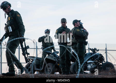 Us Border Patrol-Agenten watch illegals in San Ysidro, Kalifornien am Dezember 2, 2018. Mit wachsender Frustration an die Dauer der Asylverfahren, ein Dutzend Migranten entscheiden, den Grenzzaun, teilt den Vereinigten Staaten und Mexiko zu springen. Foto von Ariana Drehsler/UPI Stockfoto