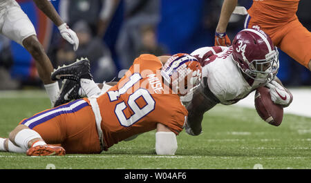 Alabama Crimson Tide zurück laufen Damien Harris (34) fällt die Kugel als er nach Clemson Tiger Sicherheit Tanner Muse gebracht (19) im ersten Quartal von der Allstate Sugar Bowl im Mercedes-Benz Superdome am 1. Januar 2018 in New Orleans. Foto von Mark Wallheiser/UPI Stockfoto