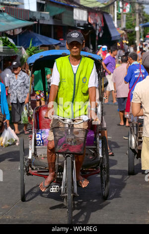 Ein Fahrer mit einem der wenigen verbliebenen samlor oder dreirädrige Zyklus Rikschas in Thailand, auf einem Markt in Pamukkale in der Nähe von Bangkok Stockfoto