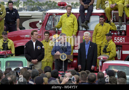 Us-Präsident George W. Bush spricht zu Feuerwehrmänner von der Rückseite der Pickup Truck bei einem Besuch der Brand Camp in Gillespie Flugplatz in El Cajon, Kalifornien, November 4, 2003. Bush traf sich mit Feuerwehrmänner, die die Flammen, die sich über mehr als 743,000 Hektar fegte gekämpft, getötet 22, und tausend Menschen obdachlos. Der Präsident Befragten auch die Region mit dem Hubschrauber und Fuß mit Kalifornien reg. Gray Davis (R) und Regler - wählen Sie Arnold Schwarzenegger (L) (UPI/EARL S. CRYER) Stockfoto