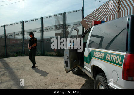 Border Patrol-Agenten E.L. Spencer prüft die Grenze Zaun, Tijuana, Mexiko und San Diego, Kalifornien, in der Nähe des Grenzübergang San Ysidro, 22. März 2005. Eine Analyse von Daten der Regierung des Pew Hispanic Center, ein eigenes Research Group in Washington DC, zeigte eine geschätzte 10,3 Mio. undokumentierte Einwanderer in den Vereinigten Staaten im letzten Jahr, eine Steigerung von über 23 Prozent von 8,4 Mio. im Jahr 2000 und wird ein heißes Thema bei den Nordamerikanischen Gipfel, wenn US-Präsident George W. Bush trifft sich mit mexikanischen Präsidenten Vicente Fox und der kanadische Premierminister Paul Martin, März 23. Stockfoto