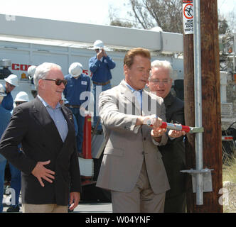 Der kalifornische Gouverneur Arnold Schwarzenegger (Mitte) zusammen mit California Public Utilities Commission Präsident Michael Peevey (links) und SDG&E GESCHÄFTSFÜHRER Edwin Guiles (rechts) symbolisch wirft der Schalter, 7. Juli 2005, in San Diego, Kalifornien, für ein neues San Diego Gas & Electric Company elektrische Stromleitungen, während Widmung Zeremonien. (UPI Foto/Earl S. Cryer) Stockfoto