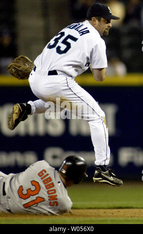 Seattle Mariners' shortstop Rich Aurilia Sprünge Baltimore Orioles'Jay Gibbons Folie zu vermeiden, während Sie ein doppeltes Spiel im achten Inning im Safeco Field am Sonntag, 18. Mai 2004 in Seattle, WA. Die Orioles schlagen die Seemänner 7-2. (UPI Foto/Jim Bryant) Stockfoto