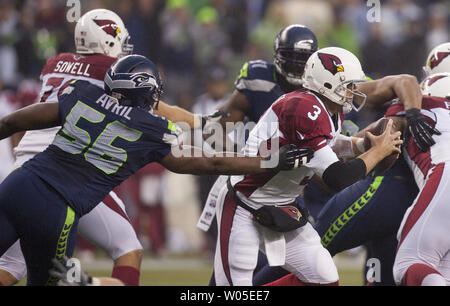 Arizona Cardinals quarterback Carson Palmer kriecht aus der Reichweite der Seattle Seahawks Verteidigung ende Cliff Avril (56) Während des vierten Quartals bei CenturyLink Feld in Seattle, Washington am 22. Dezember 2013. Die Kardinäle schlagen die Seahawks 17-10. UPI/Jim Bryant Stockfoto