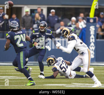 Seattle Seahawks Quarterback Russell Wilson (3) geht in Betrieb zurück Marshawn Lynch für ein 4 Yard gewinnen gegen die St. Louis Rams im dritten Quartal bei CenturyLink Feld in Seattle, Washington am 29. Dezember 2013. Wilson abgeschlossen 15 von 23 Pässe für 172 Yards und einen Touchdown und Lynch für 97 Yards gehetzt, fing einen Pass für vier Yards und erzielte einen Touchdown im Gewinn. Die Seahawks klammerte die NFC West Titel und Heimvorteil in den Playoffs mit einem 27-9 Sieg über den St. Louis Rams. UPI/Jim Bryant Stockfoto