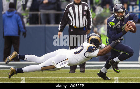 Seattle Seahawks Quarterback Russell Wilson (3) für einen 6-yards Verlust durch St. Louis Rams Eugene Sims (97) im vierten Quartal bei CenturyLink Feld in Seattle, Washington am 29. Dezember 2013 behandelt wird. Seahawks klammerte die NFC West Titel und Heimvorteil in den Playoffs mit einem 27-9 Sieg über den St. Louis Rams. Wilson abgeschlossen 15 von 23 Pässe für 172 Yards und einen Touchdown im Gewinn. UPI/Jim Bryant Stockfoto