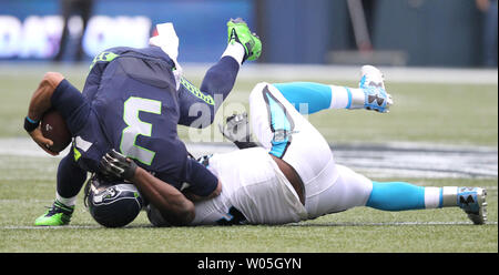 Seattle Seahawks Quarterback Russell Wilson auf seinem Kopf ist durch Carolina Panthers defensive Ende Kony Ealy an CenturyLink Feld in Seattle stellte sich am 18. Oktober 2015. Die Leoparden von hinten kam mit 32 verbleibenden Sekunden im 4. Quartal zu schlagen, um die Seahawks 27-23. Foto von Jim Bryant/UPI Stockfoto