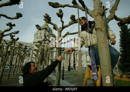 Vietnam Veteranen Mario's napper" Benfield und Troy Aney zwei der 3000 mens Krawatten aus der Platanen an der San Francisco City Hall in Erinnerung an die 3000 US-Soldaten, die im Krieg im Irak gestorben sind, hängen, in San Francisco am 2. Januar 2007 neu zu positionieren. (UPI Foto/Aaron Kehoe) Stockfoto