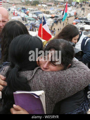 Verwandte Hug als Zubereitungen die 33 eingeschlossenen Bergleute an San Jose Mine, Chile am 11. Oktober 2010 zu retten. Wenn alles gut geht, sagen Beamte die ersten Bergleute wird in ein paar Tagen über einen 20-minütigen Fahrt in einer Rettungskapsel mehr als 2.000 Meter unter die Oberfläche gebracht werden. Die Bergleute sind seit mehr als zwei Monaten gefangen. UPI/Sebastian Padilla Stockfoto
