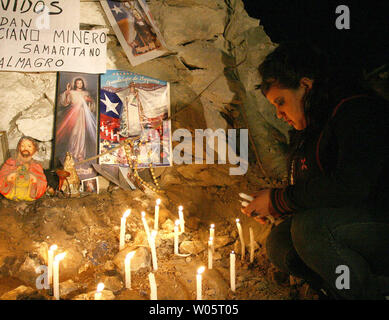 Verwandte Kerzen in der Nähe von religiösen Symbolen wie Vorbereitungen der 33 eingeschlossenen Bergleute an San Jose Mine, Chile am 12. Oktober 2010 zu retten. Wenn alles gut geht, sagen Beamte die ersten Bergleute werden innerhalb von einem Tag über eine 20-minütige Fahrt in einer Rettungskapsel mehr als 2.000 Meter unter die Oberfläche gebracht werden. Die Bergleute sind seit mehr als zwei Monaten gefangen. UPI/Sebastian Padilla Stockfoto