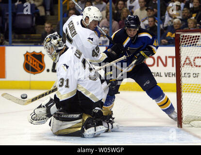 Pittsburgh Penguins Torhüter Sebastien Caron bommeln Speichern als Pinguine Robert Scuderi aus kämpft St. Louis Blues Mark Rycroft in der ersten Periode am Savvis Center in St. Louis am 14. Februar 2004. (UPI Foto/Rechnung Greenblatt) Stockfoto