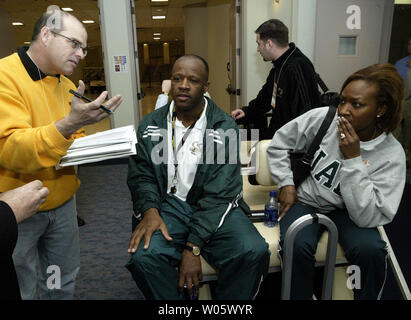 Mike Anderson, Leiter Basketballtrainer für die Universität von Alabama Birmingham Gespräche mit Berichten von der Rückseite einer Golfkarre als Ehefrau, Marcheita istens in, während der Praxis an der Edward Jones Dome in St. Louis am 25. März 2004. UAB, Kansas im ersten Spiel der NCAA Men's World Basketball Turnier am 26. März. (UPI Foto/Rechnung Greenblatt) Stockfoto