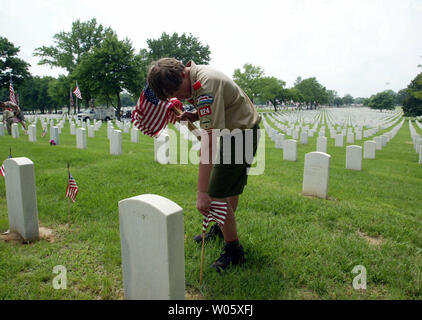 Boy Scout David Dempsey (14) der Pack 824 Orte eine amercan Flagge auf einem Grab bei Jefferson Barracks Natoinal Friedhof in St. Louis County, Mo am 30. Mai 2004. Etwa 4000 Pfadfinder sammeln auf dem Friedhof für die jährliche Memorial Day', 'Event, wo kleine amerikanische Flaggen auf alle "152.000 Gräber von kriegstoten platziert sind. (UPI Foto/Rechnung Greenblatt) Stockfoto