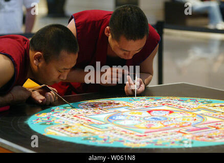 Mitglieder des Lamas von Drepung Loseling Kloster ein Mandala sand Malerei an der Saint Louis Art Museum in St. Louis erstellen Am 29. April 2005. Die 20.000 Jahre alten Tradition der farbigen Sand Malerei handelt es sich um Millionen von Sand auf eine flache Plattform festgelegt sind über einen Zeitraum von mehreren Tagen. Bei der Abschlussfeier, die Mönche Ort, um einige der Sand in Flaschen und der Rest in den nächsten Körper von Wasser, der Sand auf die Erde. (UPI Foto/Rechnung Greenblatt) Stockfoto