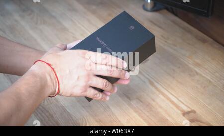 Der Mensch ist immer bereit zu öffnen. Seine Hände sind holding Cap von Telefonen Paket Kiew, Ukraine 15. Juni 2019 Stockfoto