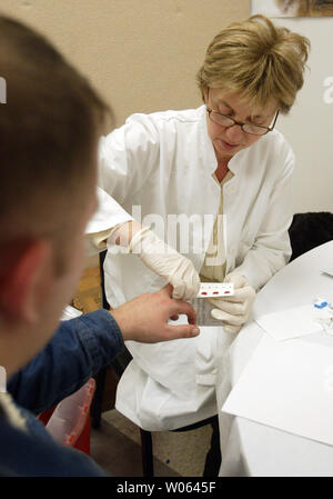 Liujana Simvnovic, eine Krankenschwester für die Internationale Kommission für Vermisste Personen (ICMP) nimmt Blutproben von Mirnes Ramic in St. Louis am 11. Dezember 2005. Das ICMP ist die DNA-Proben, um hoffentlich erkennen bleibt in Massengräbern in der gesamten ehemaligen Jugoslawien gefunden. Über 40 tausend Menschen fehlen infolge der Konflikte, die auf dem Balkan zwischen 1991 und 1995 ausbrach. Über 40 000 Bosnier haben im St. Louis Bereich wegen des Konflikts umgesiedelt. Die ICMP-Hoffnungen 200 Blutproben von St. Louis zu sammeln. (UPI Foto/Rechnung Greenblatt) Stockfoto