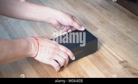 Mans Hände nähern Smartphones black box mit Huawei Mate 20 X Logo auf Holz- Hintergrund. Er hält seine obere Kappe Kiew, Ukraine 15. Juni 2 Stockfoto