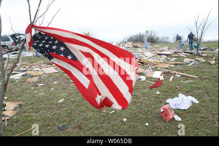 Eine amerikanische Flagge gebunden, die von einem Baum, fliegt im Wind am 12. März, in der Nähe ein Haus, das durch einen Tornado zerstört wurde, während die freiwilligen durch Rückstände in Perry County in der Nähe der kleinen Stadt St. Mary etwa 80 Meilen südlich von St. Louis am 11. März sichten. Zwei Menschen wurden getötet, als ein Mann und eine Frau in einem Auto unterwegs waren und die starken Winde der Wagen geschoben 75 Yards von der Straße in ein propantanks. 17 Andere in der kleinen Gemeinschaft wurden verletzt. Mehrere Tornados in einem 30 Quadratkilometer Fläche, in den Gemeinschaften in Missouri und Illinois gelandet. (UPI Foto/Rechnung Greenblatt) Stockfoto