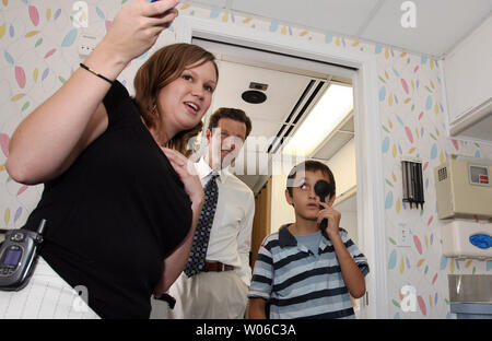 Rep. Russ Carnahan (D-St. Louis) Hört sich als screener Johanna Stevens (L) St. Louis Children's Hospital Tests die Augen der vierten Sortierer Izudin Ganovic an Bord der "Gesunde Kids Express" bei einem Besuch der Hancock Volksschule in St. Louis am 29. August 2007. Carnahan ist ein Besuch der mobil Screening Unit und mehrere andere Gesundheitseinrichtungen während seiner "Investitionen in das Gesundheitswesen ... Investieren in unsere Kinder, "Gesundheit Tour im östlichen Teil von Missouri. (UPI Foto/Rechnung Greenblatt) Stockfoto