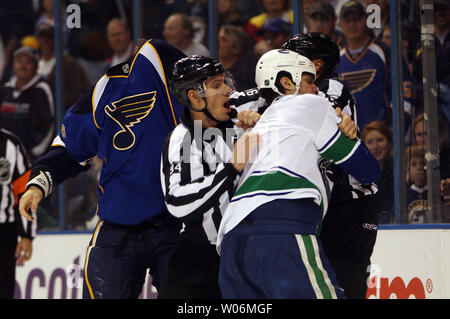 Beamter, die St. Louis Blues BJ Crombeen (L) und Vancouver Canucks Kevin Bieksa während ihrem Kampf in der ersten Periode im Scottrade Center in St. Louis am 10. November 2009 zu trennen. UPI/Rechnung Greenblatt Stockfoto