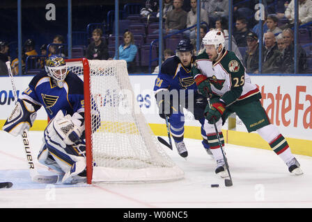 St. Louis Blues Torwart Chris Mason (L) Uhren als Minnesota Wild Eric Belanger (25) bringt den Puck um von der Rückseite des Net mit dem Blues Patrik Berglund (21) Verteidigung in der ersten Periode im Scottrade Center in St. Louis am 14. Januar 2010. UPI/Rechnung Greenblatt Stockfoto