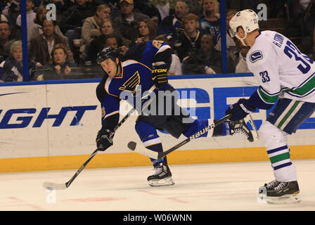 St. Louis Blues BJ Crombeen (L) nimmt einen Slap shot auf Ziel, nachdem Sie rund um Vancouver Canucks Henrik Sedin in der ersten Periode im Scottrade Center in St. Louis am 20. Dezember 2010. UPI/Rechnung Greenblatt Stockfoto