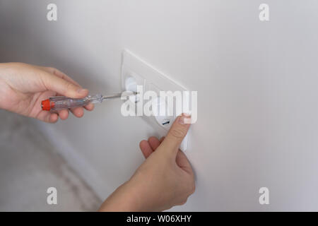 Nicht-weiblichen arbeiten. Reparatur und Dekoration. Frau Reparaturen Steckdosen in eine neue Wohnung Stockfoto