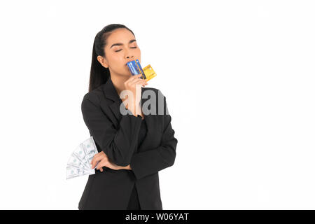 Schöne asiatische business Frau trägt einen schwarzen Anzug, mit der rechten Hand mit einem blauen und gelben Kreditkarte,, Küssen eine Kreditkarte an der Mündung, links Stockfoto