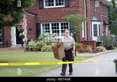 Ein St. Louis County Polizisten entfernt Beweise an einem Haus, wo eine Mutter ihre beiden Kinder selbst in Gelndale, Missouri am 29. Juli 2012 ermordet. Die Polizei sagt der Vater rief die Polizei, nachdem er Schüsse hörte. Polizei glauben der Mutter schoß ihre zwei Kinder im Alter von neun und elf und dann sich. Zwei Opfer waren zu einem Bereich Krankenhaus, wo sie tot ausgesprochen wurden und man Opfer war ausgeprägte Tote an der Szene transportiert. Der Vater wird von der Polizei gefragt. UPI/Rechnung Greenblatt Stockfoto