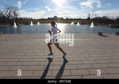 Ein Jogger vorbei die Emerson Grand Bassin in Forest Park in St. Louis 11. Januar, 2013. Die Temperaturen erreichen 67 Grad in St. Louis, Wanderer, Läufer, Radfahrer und Golfer die Sonne zu expirence vor kalten Temperaturen in der kommenden Woche zurück. UPI/Rechnung Greenblatt Stockfoto