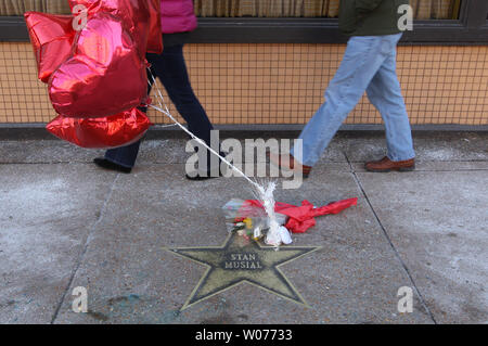 Menschen gehen vorbei an den Ballons und Blumen auf den Stan Musial Stern auf dem St. Louis des Ruhmes in University City, Missouri am 23. Januar 2013 laufen. Musial, einem ehemaligen St. Louis Kardinal und Mitglied der National Baseball Hall of Fame, starb im Alter von 92 Jahren am 19. Januar. UPI/Rechnung Greenblatt Stockfoto