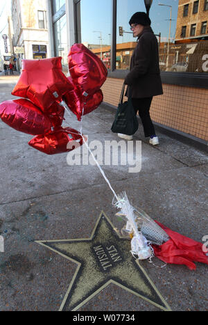 Eine Frau geht Vergangenheit Ballons und Blumen auf den Stan Musial Stern auf dem St. Louis Walk of Fame in University City, Missouri am 23. Januar 2013. Musial, einem ehemaligen St. Louis Kardinal und Mitglied der National Baseball Hall of Fame, starb im Alter von 92 Jahren am 19. Januar. UPI/Rechnung Greenblatt Stockfoto