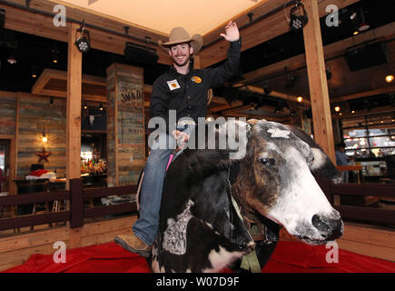 Professionelle bullrider Lukas Snyder von Springfield, Missouri versucht, seine Hand an, Ozzie, der mechanischen Bullen während der Eröffnung - Festlichkeiten an der PBR Bar in Ballpark Village in St. Louis am 4. April 2014. Der PBR Bar ist der siebte im Land zu öffnen. UPI/Rechnung Greenblatt Stockfoto