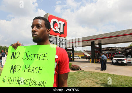 Demonstrant Allen Smith hält seine Anmeldung für Verkehr, als er außerhalb der QuikTrip Gas Station, nach einer Nacht von Plünderungen und Krawalle und Brandstiftungen in Ferguson, Missouri am 11. August 2014 verbrannt wurde. Die Menschen sind wegen der Ferguson Polizei schießen und Tod eines unbewaffneten schwarzen Teenager Michael Braun am 9. August 2014 umgekippt. In allen über 20 Unternehmen, die eine nachhaltige Beeinträchtigung der nach einer Mahnwache heftig gedreht. UPI/Rechnung Greenblatt Stockfoto