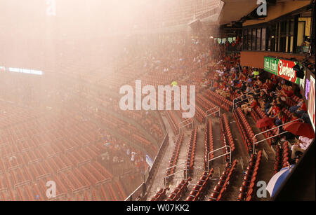 Fans versuchen, Schutz von einem schweren Regen, verzögert den Start der Chicago White Sox-St. Louis Cardinals baseball spiel am Busch Stadium in St. Louis am 1. Juli 2015. Foto von Bill Greenblatt/UPI Stockfoto