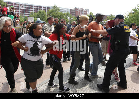 Die Polizei versucht die Demonstranten vom Vorrücken Arm in Arm in Richtung Eingang des Thomas F. Eagleton Federal Building in St. Louis am 10. August 2015 zu halten. Eine Gruppe von rund 200 Demonstranten marschierten, um das Gebäude als Teil eines Tag der Ungehorsam mit dem einjährigen Jubiläum des Michael Brown Jr. schießenden Tod statt. Etwa 50 Personen wurden festgenommen. Foto von Bill Greenblatt/UPI Stockfoto