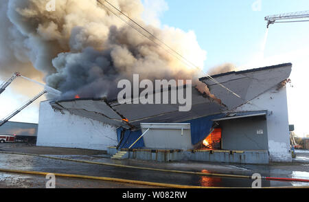 Eine Rückwand beginnt zu fallen als 5-Alarm Feuer außer Kontrolle in einem Lagerhaus in St. Louis am 15. November 2017 tobt. Fast 200 St. Louis Feuerwehrmänner kämpften die Lager mit Papier Produkte und fast 200 tausend Kerzen. Foto von Bill Greenblatt/UPI Stockfoto