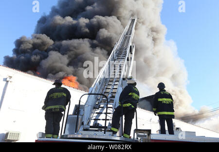 St. Louis Feuerwehrmänner können nur zusehen, wie ein Feuer außer Kontrolle in einem Lager während fünf - alarm Brand in St. Louis am 15. November 2017 tobt. Fast 200 St. Louis Feuerwehrmänner kämpften die Lager mit zahlreichen Papierprodukte und fast 200 tausend Kerzen. Foto von Bill Greenblatt/UPI Stockfoto